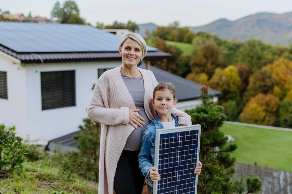 Anlagenbetreiber vor ihrem Haus mit einer PV-Anlage