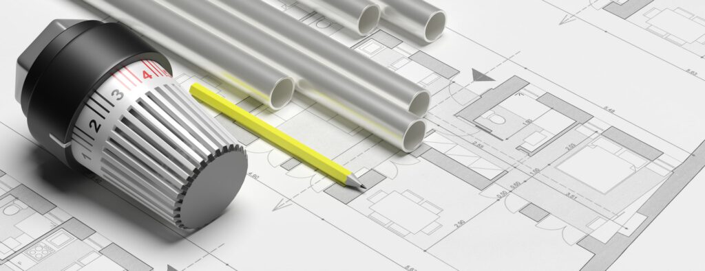 Bleistift mit einem Thermostat und Heizrohren auf einem Bauplan