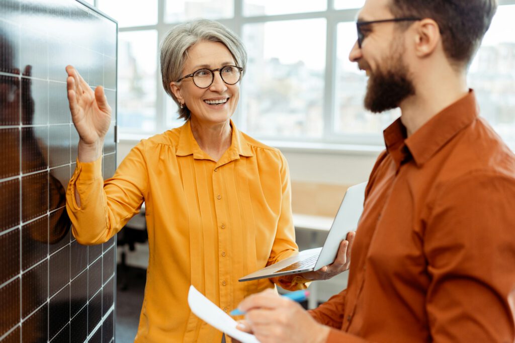 Frau erklärt einem Mann den Anlagennutzungsgrad am Beispiel eines Moduls